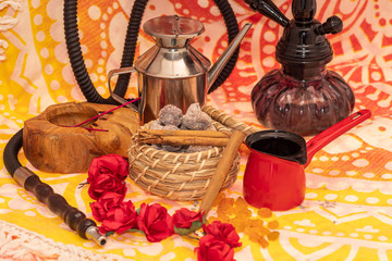 Still life consisting of hookah, flowers, figs, cinnamon, candles and tea-making utensils