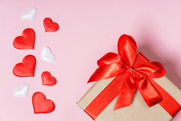 Many of red hearts and holiday box on pink paper background for valentines day