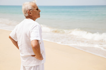 Happy senior man walking on the beach