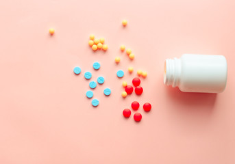 multicolored pharmaceutical pills thermometer, bottle, phonendoscope on a pink background. Copy space. the concept of health. concept  of life. assorted medicines. bright pills. coronavirus