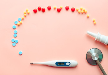 multicolored pharmaceutical pills thermometer, bottle, phonendoscope on a pink background. Copy space. the concept of health. concept  of life. assorted medicines. bright pills. coronavirus