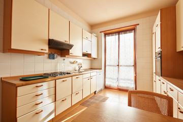 Fototapeta na wymiar Kitchen interior with wooden table in a sunny day in normal apartment