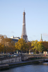 Fototapeta na wymiar Eiffel tower and with Seine river and autumn trees in a sunny day in Paris, France