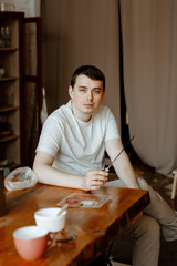 A young man in home clothes is engaged in cooking in his kitchen.