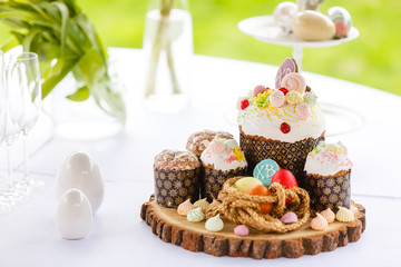 Easter sweet bread Orthodox kulich, paska, willow twigs. Easter Colorful eggs on white background. Holidays breakfast. Space for text.
