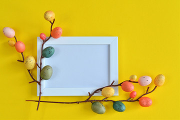 photo frame and multi-colored quail eggs on a yellow background. Easter Postcard Template