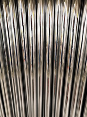 Aluminum pipes. Texture of metal pipes of the same diameter. The vertical arrangement of the elements.