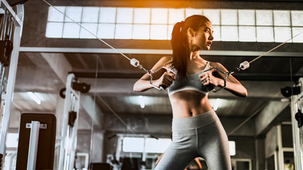 young fitness woman execute exercise with exercise-machine in gym, horizontal photo.Doing Workout Exercises.Relaxing After Fitness Training in gym.