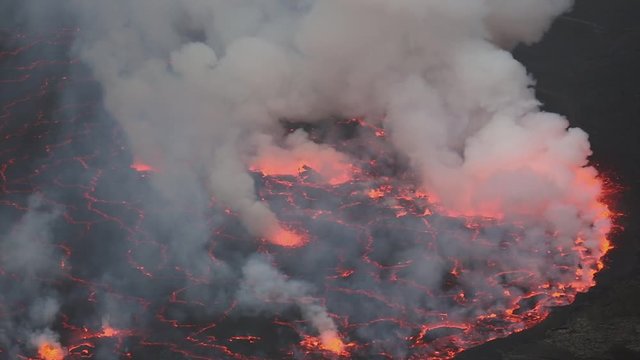 Bubbling lava and smoke in a round crater of Nyiragongo volcano, Congo