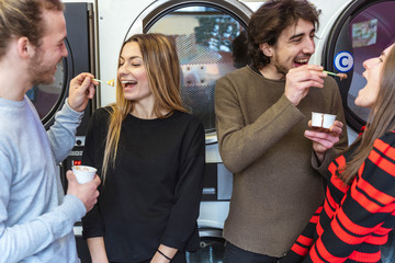 group of millennial friends are eating ice cream and washing clothes