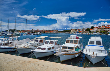 Fototapeta premium Fishing and sailing boats at the harbor. Sunny summer view of Tribunj port. Morning seascape, Adriatic sea, Croatia, Europe. Beautiful world of Mediterranean countries. Traveling concept background..