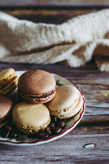 Macarons goût chocolat café vanille dans une petite assiette