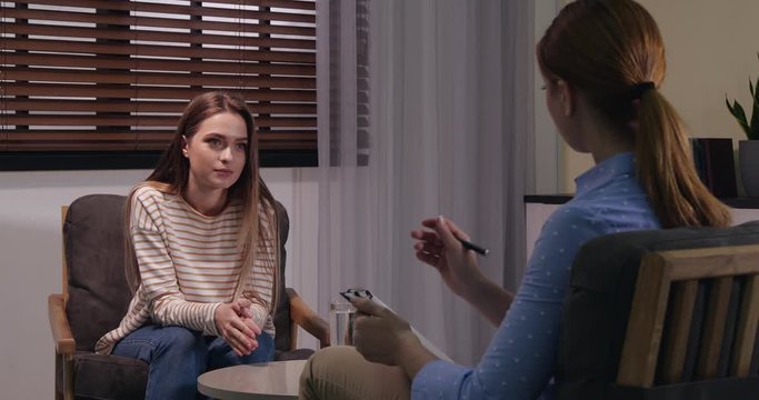 Psychologist working with young woman in office