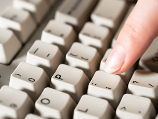 Female forefinger pushes SEMICOLON button. Close-up