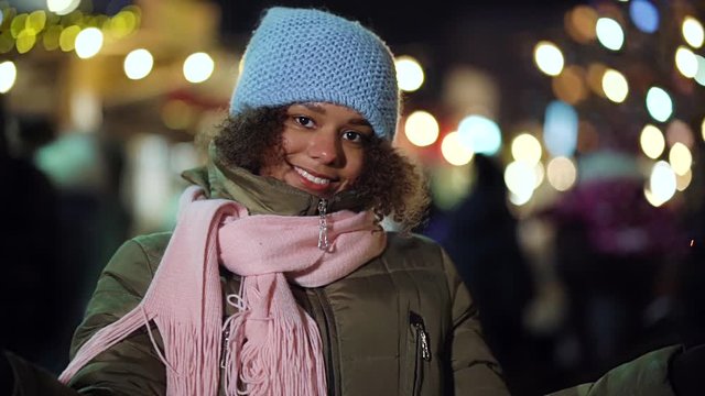 Joyful black girl with sparklers on Christmas holiday market