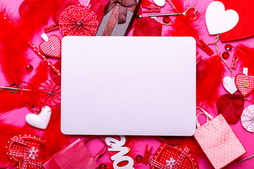 Table top view image of decoration valentine's day background with empty white blank . Flat lay arrangement of red shape and gift box with essential items on modern pastel pink paper.