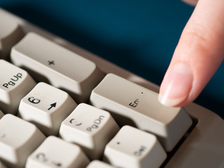 Female forefinger pushes ENTER NUMPAD button. Close-up