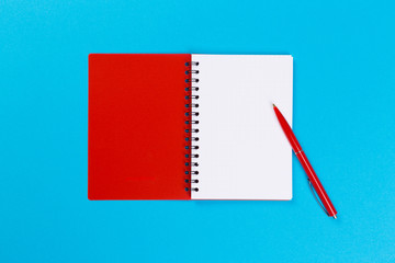 top view of empty open notebook on blue background, office equipment, school supplies and education concept