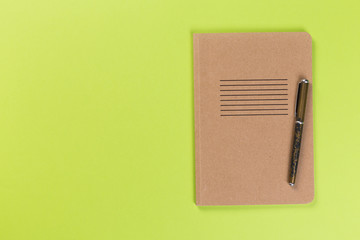 top view of blank open notebook or notepad on green background, office equipment, school supplies and education concept