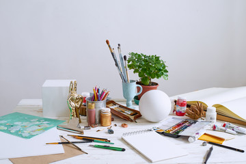 Artist studio with paper and utensils. Workspace of designer illustrator with lots of materilals and equipement.