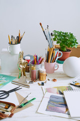 Artist studio with paper and utensils. Workspace of designer illustrator with lots of materilals and equipement.