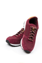 a pair of new burgundy, cherry sneakers or athletic shoes isolated on a white background.