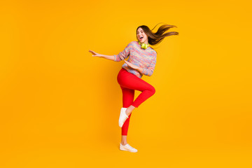 Fototapeta na wymiar Full length photo positive cheerful dj girl listen melody music playlist headset dance dancer on disco floor party wear red pants trousers sweater gumshoes isolated yellow color background