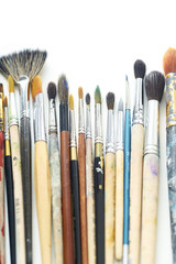 Used artistic paintbrushes isolated on white background. Close up shot of artist's equipment