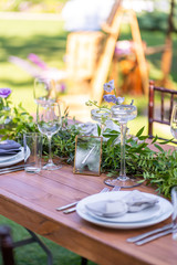 Preparing for an open-air party. Decorated with fresh flowers served tables. Table number. Decoration Details