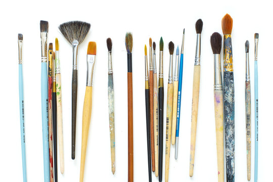 Used artistic paintbrushes isolated on white background. Close up shot of artist's equipment