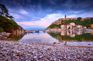 Fototapeta premium Town of Vrbnik (Verbnik) harbor view morning glow, Island of Krk, Kvarner bay archipelago, Croatia, Europe. Dramatic summer seascape of Adriatic sea. Stone beach. Incredible evening cityscape.