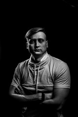 Portrait of a cheerful young guy crossed his arms over his chest.. on a black background