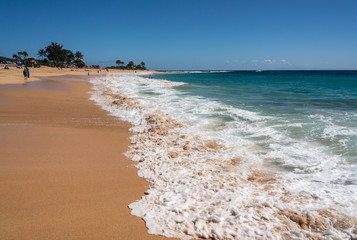 Holidaymakers on the sand of Sandy Beach on the east coast of Oahu in Hawaii in winter