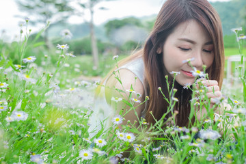 Asian women smelling white flowers in garden nature