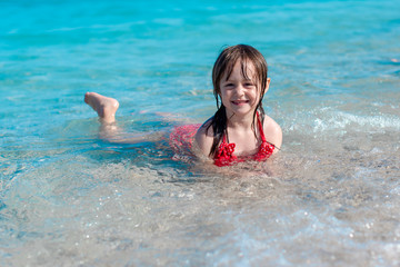 Cute little girl is playing on the beach