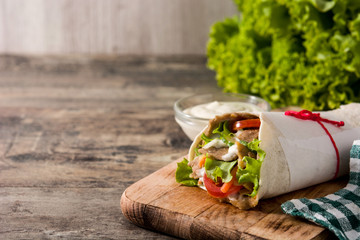 Doner kebab or shawarma sandwich on wooden table. Copy space