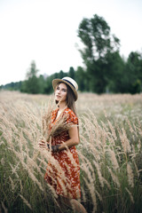 Girl in a red dress on a wheat field