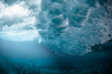 Underwater view of the surfer passing the ocean wave
