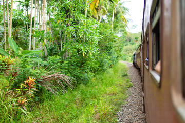 Train ride in Sri Lanka. Man hanging on a wagon