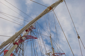 Obraz premium Rigging of a tall ship below a blue cloudy sky in sunlight in winter