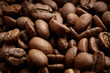  Whole brown coffee grains close-up. The aroma of coffee, selected grains, arabica, vigor, relaxation, pleasure.