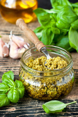 Pesto sauce and ingredients over wooden rustic background