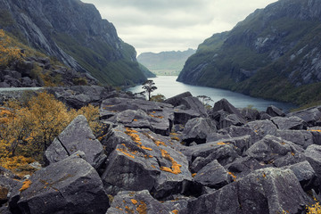 Nature, Norway landscape, Stone heaps on a pass overlooking the blue water of the fjord among  mountains in fall evening