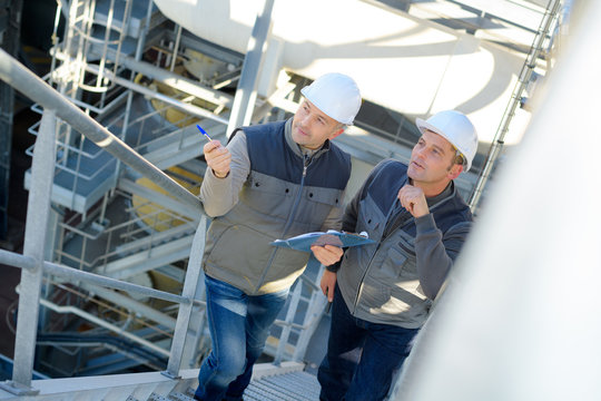 Male Industrial Factory Maintenance Workers Talking