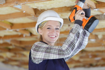female builder using cordless drill