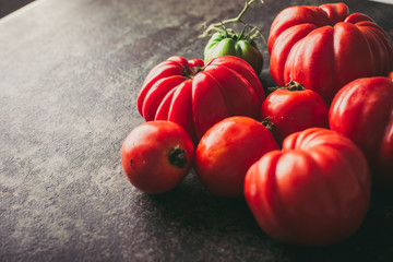 Fresh, ripe tomatoes on dark metal background.