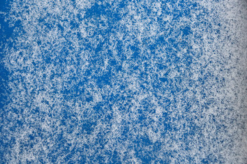 Texture of blue snowflakes on a blue background. Snow on a blue surface