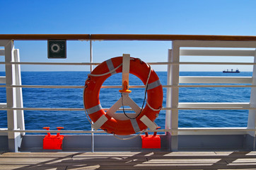 Blue Hour on empty deck with railing and life ring and panoramic ocean view from cruiseship or...