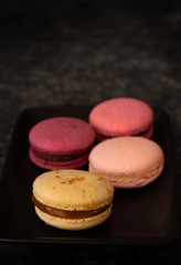 Colorfull macarons black background. Pink color macaroons.