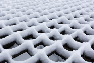 White fluffy snow formed a rhythmic pattern on the trellis.
